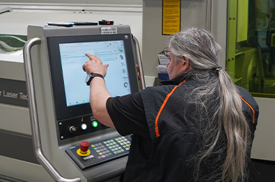 Opérateur devant le Lasertube LT7, dans l'usine de production de KTM Components